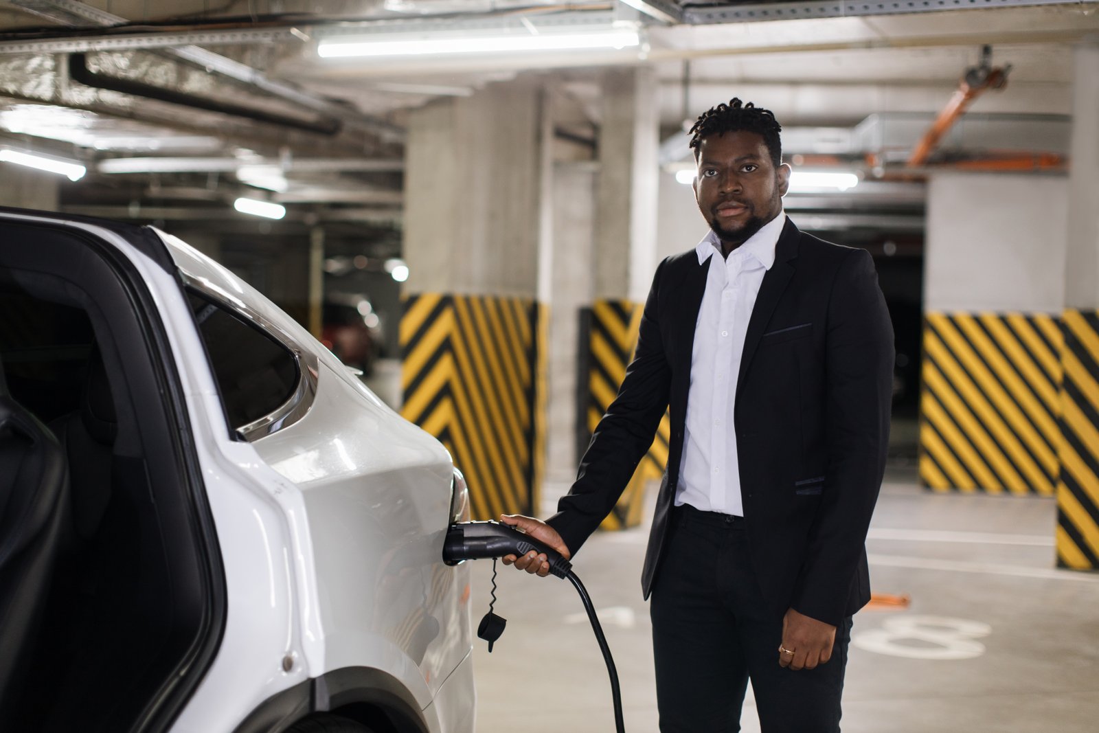 Man Working on Electric Vehicle Battery Care While Charging